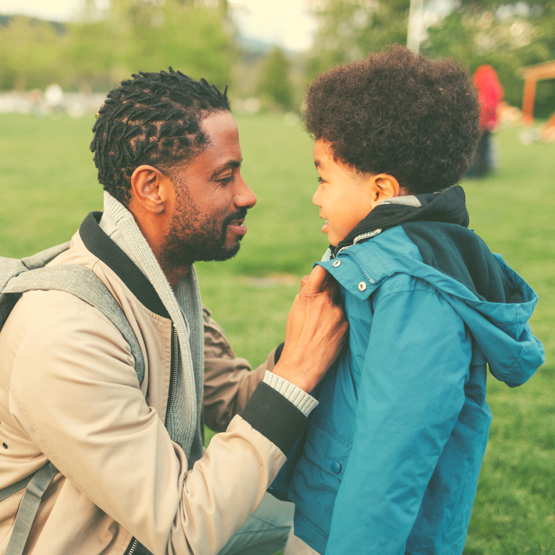 A Black father helping his son