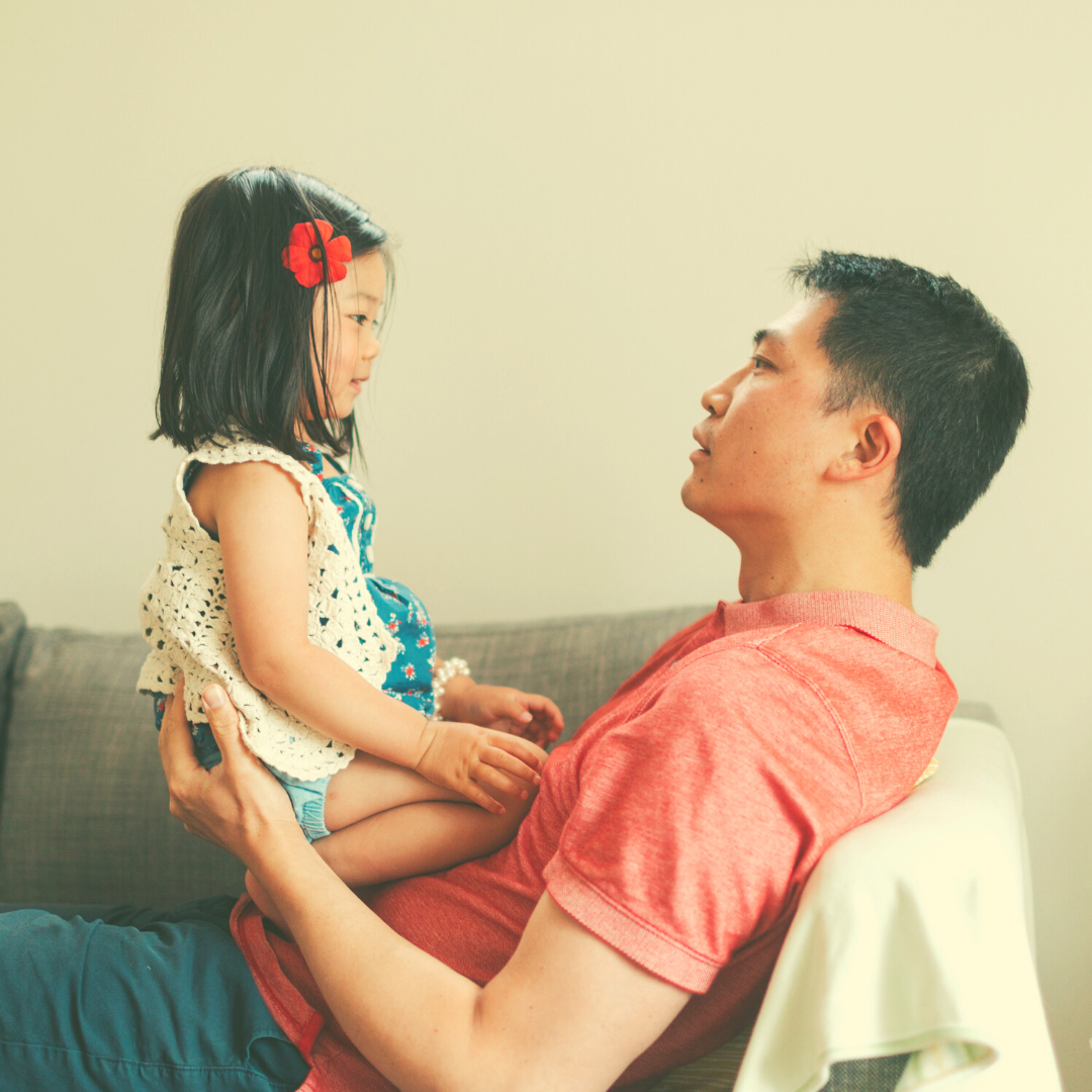 A father holding a little girl